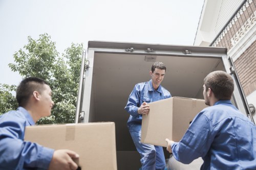 Local movers handling desks and boxes in a commercial move
